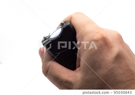 Taser in a man's hand, close-up, isolated on a white background Taser in a man's hand, close-up, isolated on a white background 95030843
