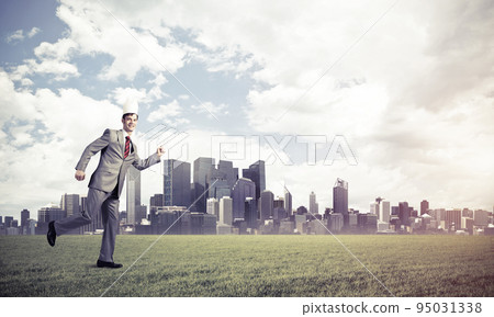 King businessman in elegant suit running on green grass and modern cityscape at background 95031338