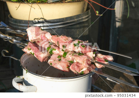 Marinated meat on skewers lying on a saucepan 95031434