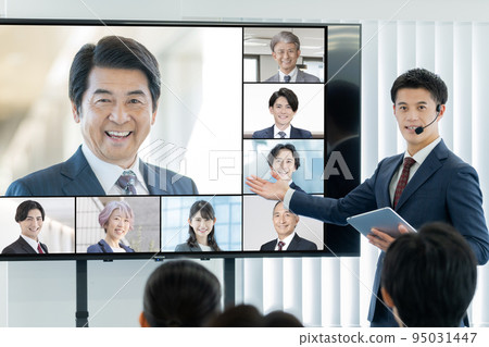 A business seminar with an external lecturer and a man moderating on a large monitor 95031447