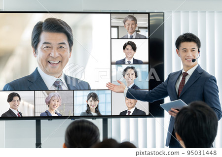 A business seminar with an external lecturer and a man moderating on a large monitor 95031448
