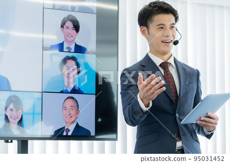 學生出現在大型顯示器上,一名男子主持商業研討會 學生出現在大型顯示器上,一名男子主持商業研討會 95031452