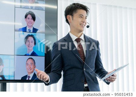 Students appearing on a large monitor and a man chairing a business seminar 95031453