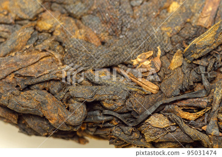 Pressed Chinese fermented Pu erh tea. Macro close up. Aromatic black puer tea. Selective focus Pressed Chinese fermented Pu erh tea. Macro close up. Aromatic black puer tea. Selective focus 95031474