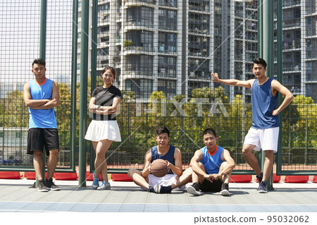 five asian young adult relaxing on an outdoor basketball court after exercising five asian young adult relaxing on an outdoor basketball court after exercising 95032062