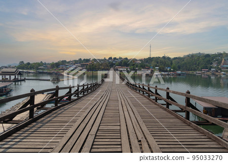 Wooden Mon Bridge with residential local houses in Mon village, nature trees, Sangkhlaburi, Kanchanaburi, Thailand in urban city town in Asia, buildings. 95033270