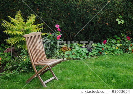 Vintage wooden chair in green country garden Vintage wooden chair in green country garden 95033694