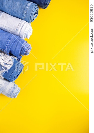 Folded blue jeans denim on paper background texture. Jeans fabric material Folded blue jeans denim on paper background texture. Jeans fabric material 95033959