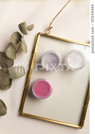 Cosmetics facial powder and blush for cheeks on natural background with dried flowers. Makeup accessories top view 95034484