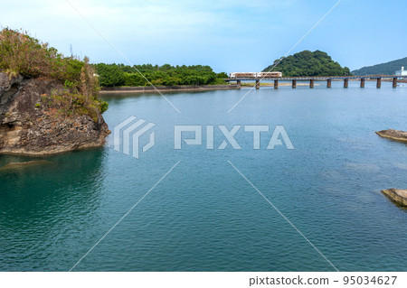 Kiha 40 on the Nichinan Line running on the iron bridge over the Hosoda River under the blue sky 95034627