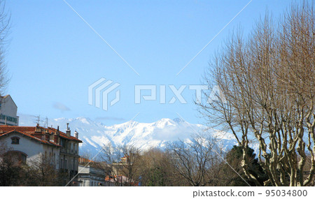 Perpignan. Panorama top view. Tiled roofs of houses and mountains with snowy peaks in the distance. Spring. March 2009. France. 95034800