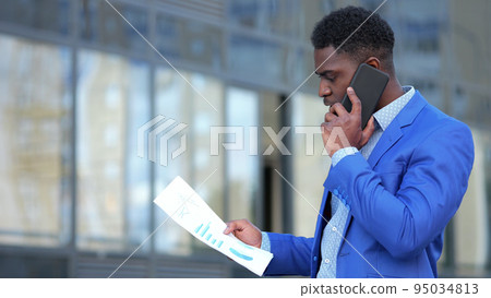 African American businessman examines monthly paper report African American businessman examines monthly paper report 95034813