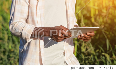 African American agronomist searches data on corn via tablet African American agronomist searches data on corn via tablet 95034815