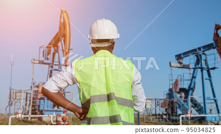 African American man controls beam-balanced pumping unit African American man controls beam-balanced pumping unit 95034825
