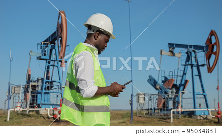 Black engineer controls development of oil by jack-pump Black engineer controls development of oil by jack-pump 95034831