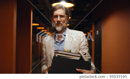 Businessman standing in office hallway 95035595