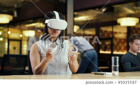 Female office worker using VR headset Female office worker using VR headset 95035597