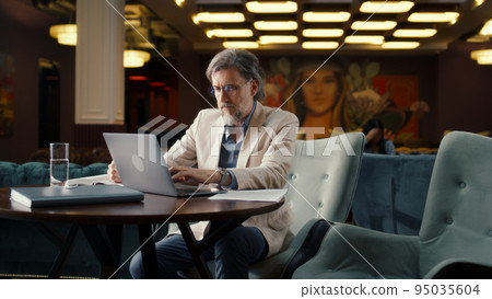 Man working with papers in office cafe Man working with papers in office cafe 95035604
