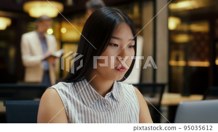 Asian woman working on laptop in office Asian woman working on laptop in office 95035612