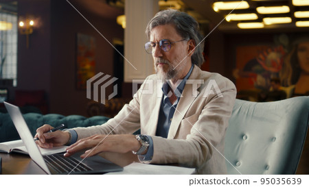 Man working with papers in office cafe Man working with papers in office cafe 95035639