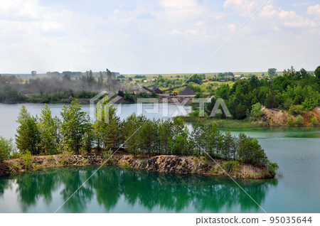 Drowned basalt quarry with stone mining works on the background Drowned basalt quarry with stone mining works on the background 95035644