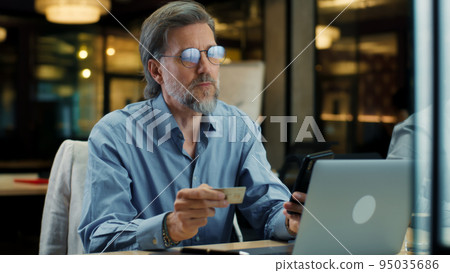 Man transferring money during office work 95035686