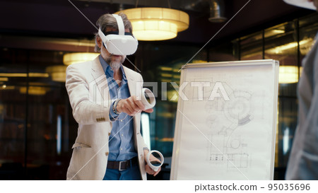 Man looking at blueprint in VR headset 95035696
