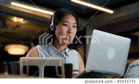 Female office worker talking with client online Female office worker talking with client online 95035715