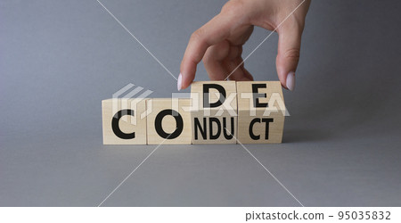 Code of conduct symbol. Businessman hand Turnes cubes and changes word Conduct to Code. Beautiful grey background. Business and Code of conduct concept. Copy space 95035832