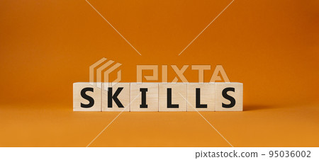 Skills symbol. Concept word Skills on wooden cubes. Beautiful orange background. Business and Skills concept. Copy space. 95036002