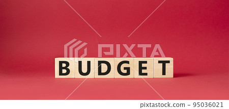 Budget symbol. Concept word Budget on wooden cubes. Beautiful red background. Business and Budget concept. Copy space. Budget symbol. Concept word Budget on wooden cubes. Beautiful red background. Business and Budget concept. Copy space. 95036021