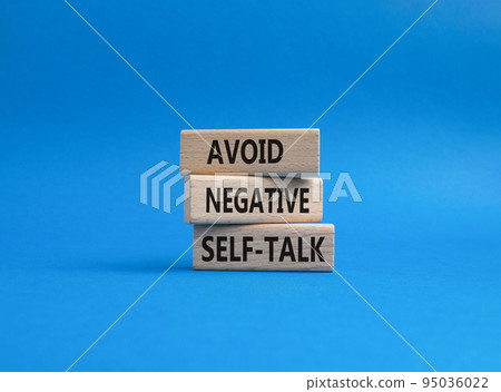 Avoid negative self-talk symbol. Concept words Avoid negative self-talk on wooden blocks. Beautiful blue background. Business and Avoid negative self-talk concept. Copy space. 95036022
