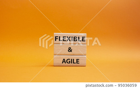 Flexible and agile symbol. Concept word Flexible and agile on wooden blocks. Beautiful orange background. Business and Flexible and agile concept. Copy space 95036059
