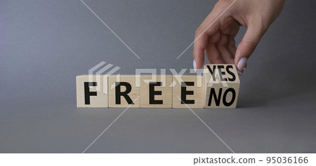 Free symbol. Businessman hand turnes wooden cubes and changes words Free YES to Free No. Beautiful grey background. Business concept. Copy space Free symbol. Businessman hand turnes wooden cubes and changes words Free YES to Free No. Beautiful grey background. Business concept. Copy space 95036166