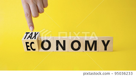 Taxonomy and economy symbol. Businessman hand points at Turned cubes with words Economy and Taxonomy. Beautiful yellow background. Business and Taxonomy and economy concept. Copy space Taxonomy and economy symbol. Businessman hand points at Turned cubes with words Economy and Taxonomy. Beautiful yellow background. Business and Taxonomy and economy concept. Copy space 95036233