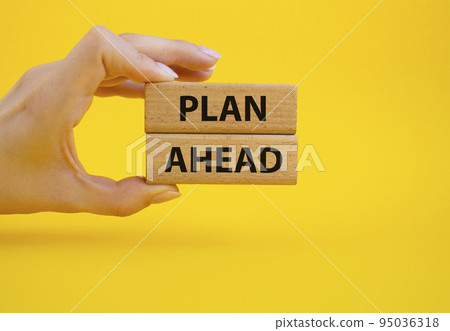 Plan ahead symbol. Wooden blocks with words 'Plan ahead'. Beautiful yellow background. Businessman hand. Business and 'Plan ahead' concept. Copy space. Plan ahead symbol. Wooden blocks with words 'Plan ahead'. Beautiful yellow background. Businessman hand. Business and 'Plan ahead' concept. Copy space. 95036318