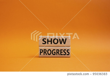 Progress symbol. Wooden blocks with words 'Show progress'. Beautiful orange background. Business and 'Show progress' concept. Copy space. 95036383