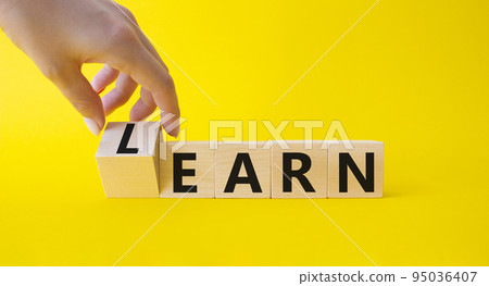 Learn or earn symbol. Businessman hand turnes wooden cubes and changes word Earn to Learn. Beautiful yellow background. Business Earn and Learn concept. Copy space. Learn or earn symbol. Businessman hand turnes wooden cubes and changes word Earn to Learn. Beautiful yellow background. Business Earn and Learn concept. Copy space. 95036407