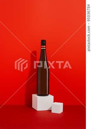 Bottle of wine on red background with deep shadows. Mock up drink with place for you lable and text Bottle of wine on red background with deep shadows. Mock up drink with place for you lable and text 95036784
