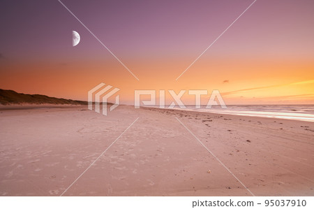 Copy space at sea with moon in the twilight night sky and calm ocean waves across a relaxing beach shore. Scenic and peaceful panoramic of a beautiful sunset with lunar background and empty landscape 95037910