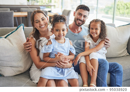 Father, mother and children smile, love and relax on the sofa together in the house living room. Portrait of happy family bonding in a lounge with happiness, care and trust in a healthy relationship 95038920
