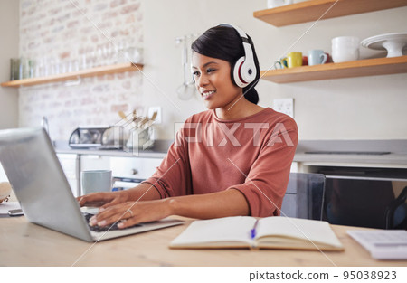 Email, music and black woman typing on the internet on a laptop while working at a table in her house. Remote African worker planning on web with technology while listening to a podcast in her home 95038923