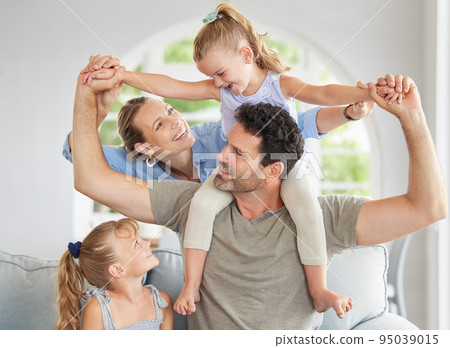 Happy family, play and bonding on a sofa in their home, cheerful and having fun. Young parents being playful and loving with their girls, enjoying a game on the weekend with fun mother and father Happy family, play and bonding on a sofa in their home, cheerful and having fun. Young parents being playful and loving with their girls, enjoying a game on the weekend with fun mother and father 95039015
