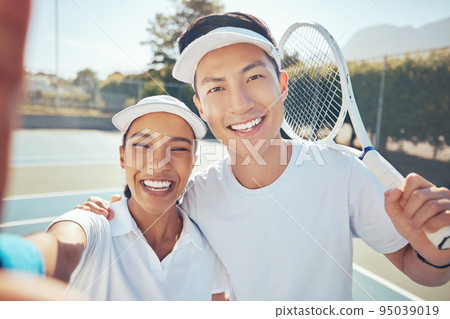 Selfie, tennis and friends with a man and woman taking a photograph on a sports court after a game or match. Training, exercise and workout with a young male and female training in sport for health Selfie, tennis and friends with a man and woman taking a photograph on a sports court after a game or match. Training, exercise and workout with a young male and female training in sport for health 95039019