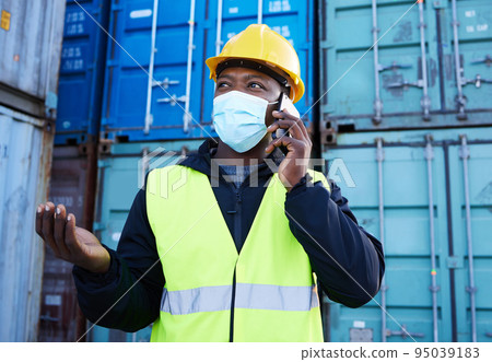 Covid, logistics and black man on phone call while working at a container warehouse. African industrial manager talking about shipping, delivery and cargo on a mobile with a face mask at storage site Covid, logistics and black man on phone call while working at a container warehouse. African industrial manager talking about shipping, delivery and cargo on a mobile with a face mask at storage site 95039183