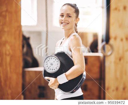 Fitness woman with weightloss scale in gym, sports studio and exercise club. Portrait of happy, strong and smile woman with healthy diet, active lifestyle and workout motivation for balanced wellness 95039472