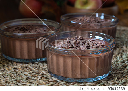Chocolate Panna Cotta dessert in glass ramekin, harvest low key background horizontal Chocolate Panna Cotta dessert in glass ramekin, harvest low key background horizontal 95039589