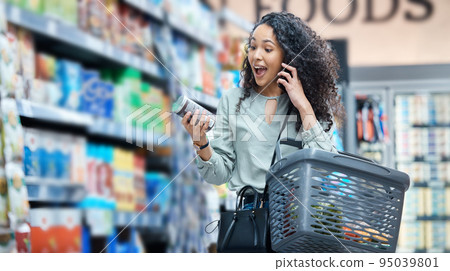 Supermarket, grocery shopping and surprise of a black woman on a phone call at a retail store. Wow, happy and omg facial expression of a customer hearing deal, price sale on stock and discount food 95039801