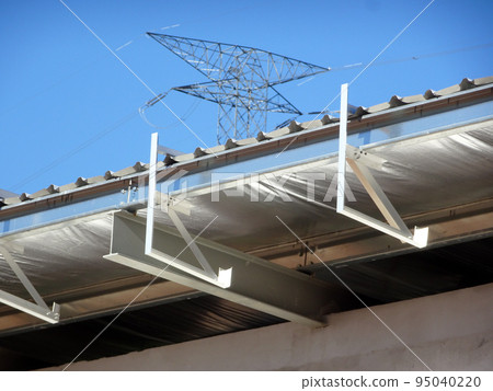 MELAKA, MALAYSIA - SEPTEMBER 16, 2022: Installation of the aluminum cladding frame at the end of the roof is underway. The metal decking roof system is equipped with a heat-resistant silsalation layer MELAKA, MALAYSIA - SEPTEMBER 16, 2022: Installation of the aluminum cladding frame at the end of the roof is underway. The metal decking roof system is equipped with a heat-resistant silsalation layer 95040220