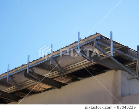 MELAKA, MALAYSIA - SEPTEMBER 16, 2022: Installation of the aluminum cladding frame at the end of the roof is underway. The metal decking roof system is equipped with a heat-resistant silsalation layer 95040229